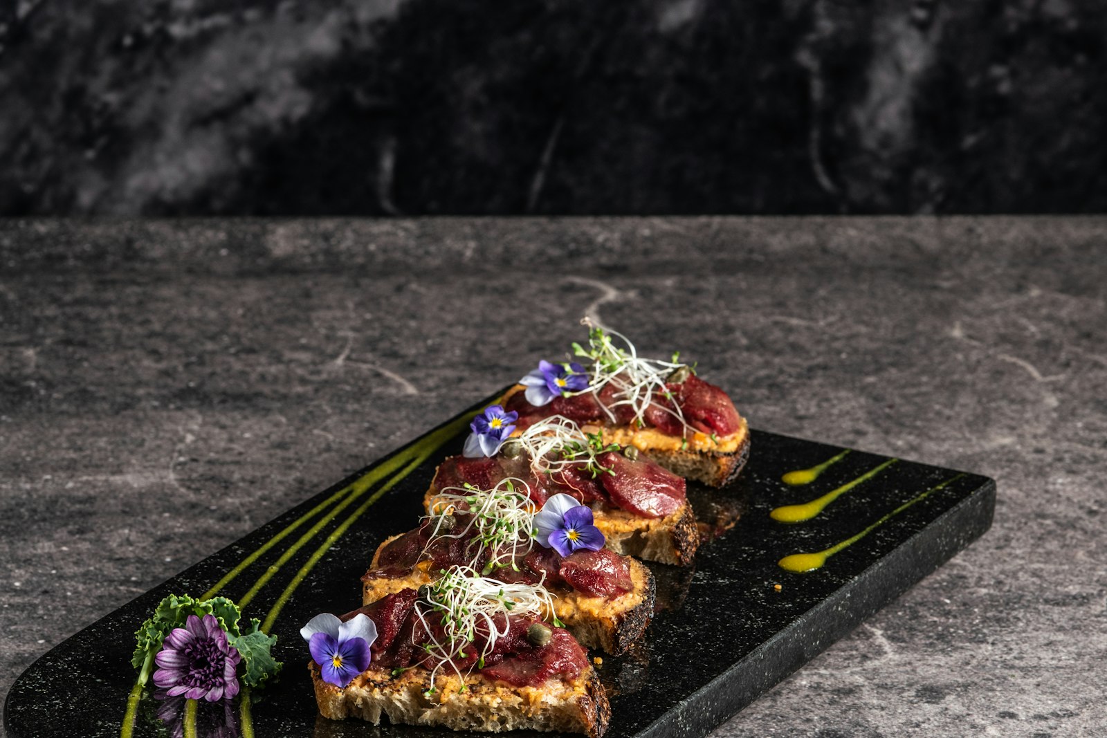 Tuna tartare bites artfully arranged on a dark platter