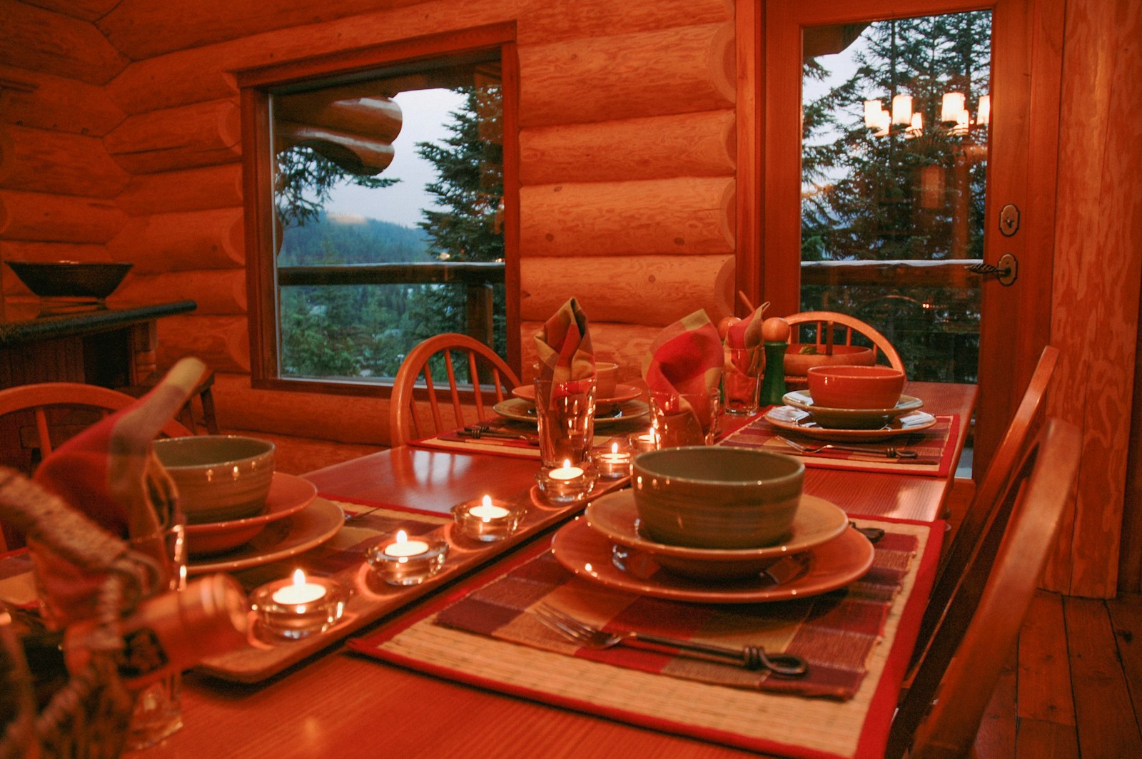 A dining table set with candles and place settings