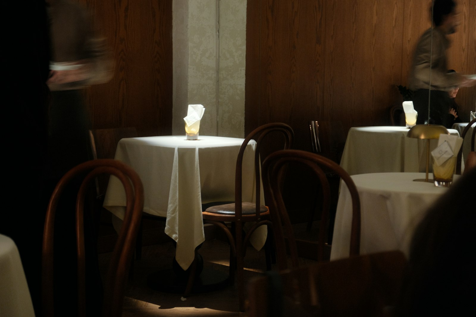 Warm, candlelit dining room at Fig & Ember with wood tables and low amber lighting