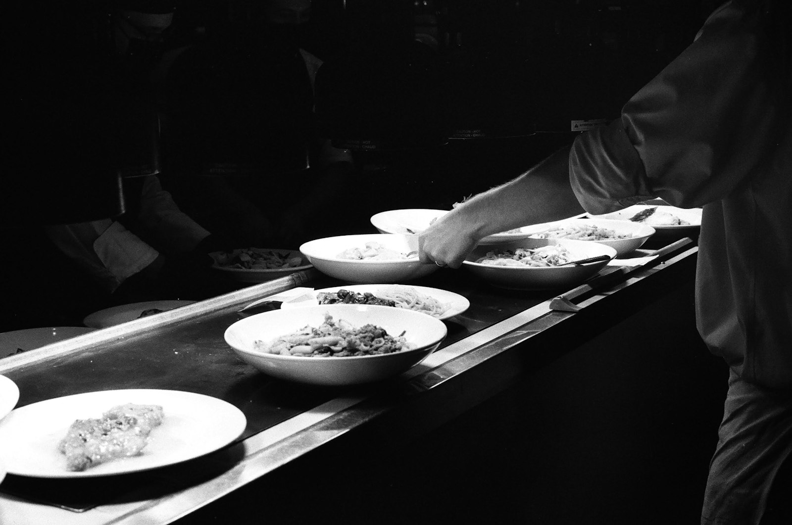 Close-up of a chef's hands plating a dish with care
